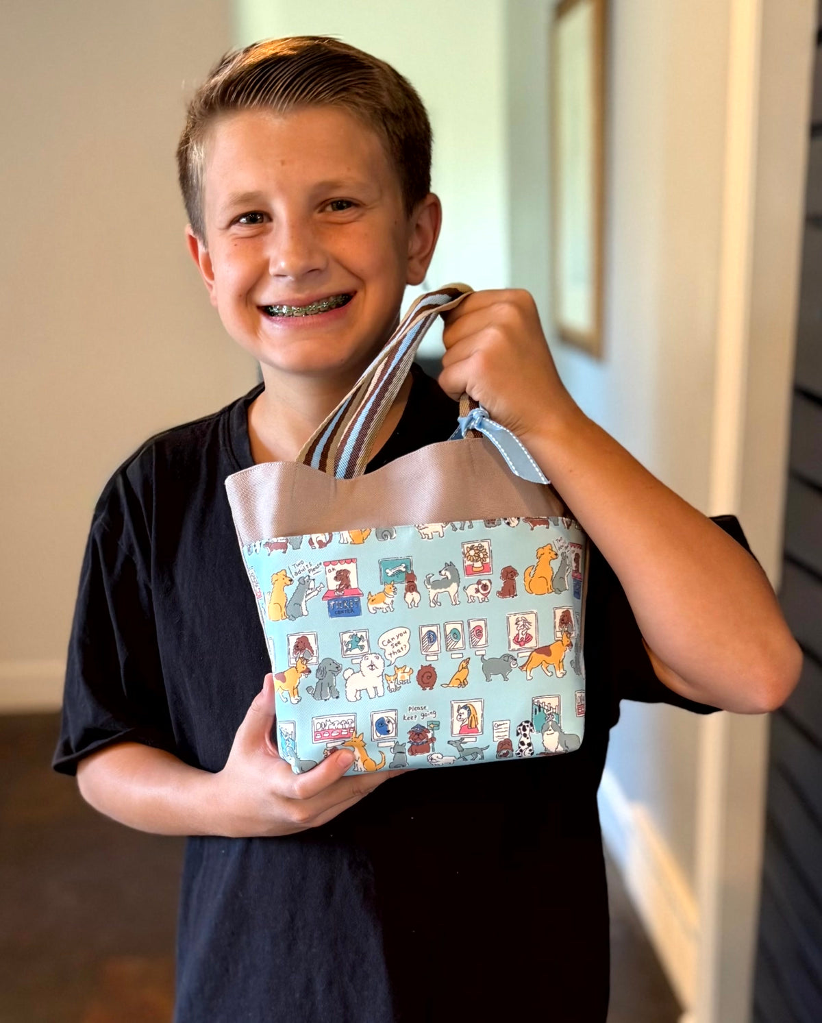 Young boy with a light gray Children's Scripture Bag with puppies print