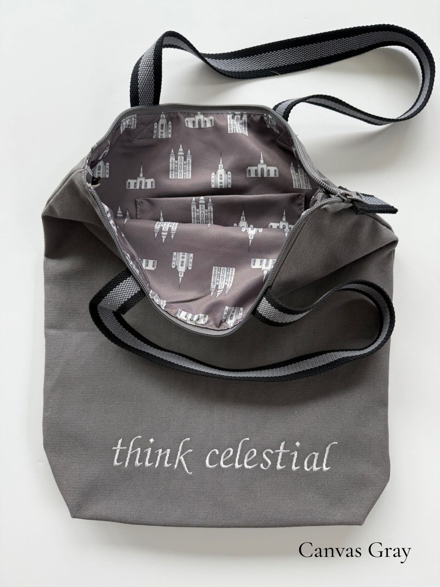 Canvas Gray temple bag with gray and black striped strap and temples lining, embroidered with “think celestial”