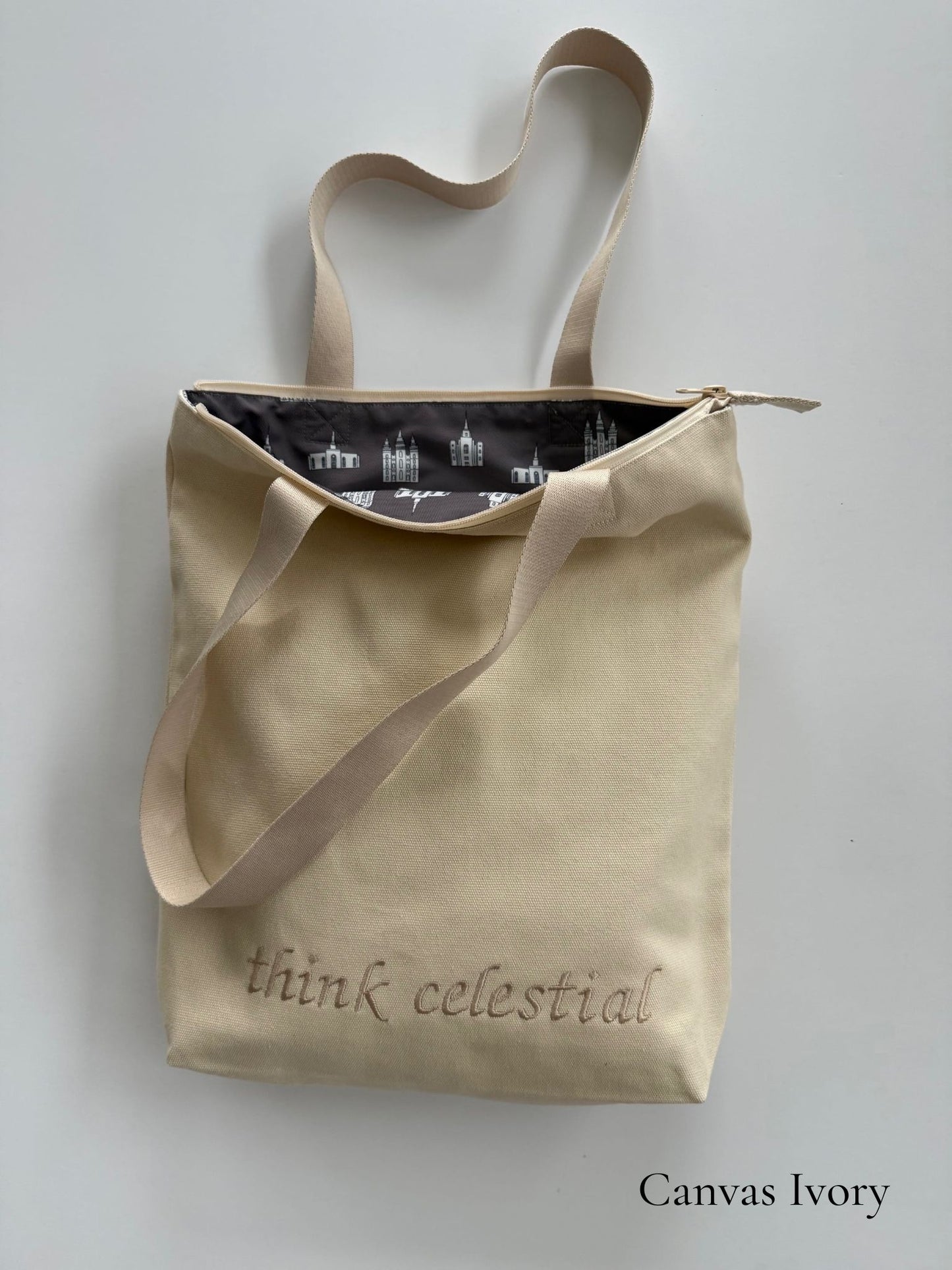 Canvas Ivory temple bag with tan strap and temples lining, embroidered with “think celestial”