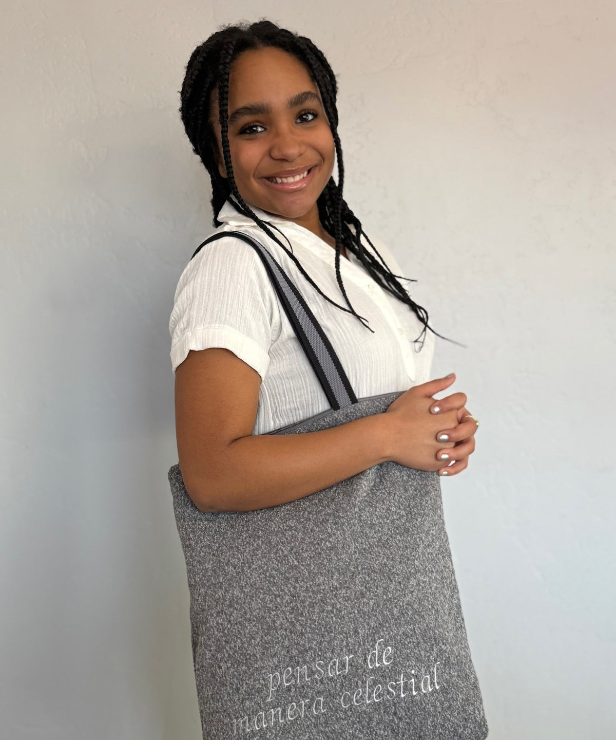 Smiling young woman with an Upholstery Gray temple bag over her shoulder