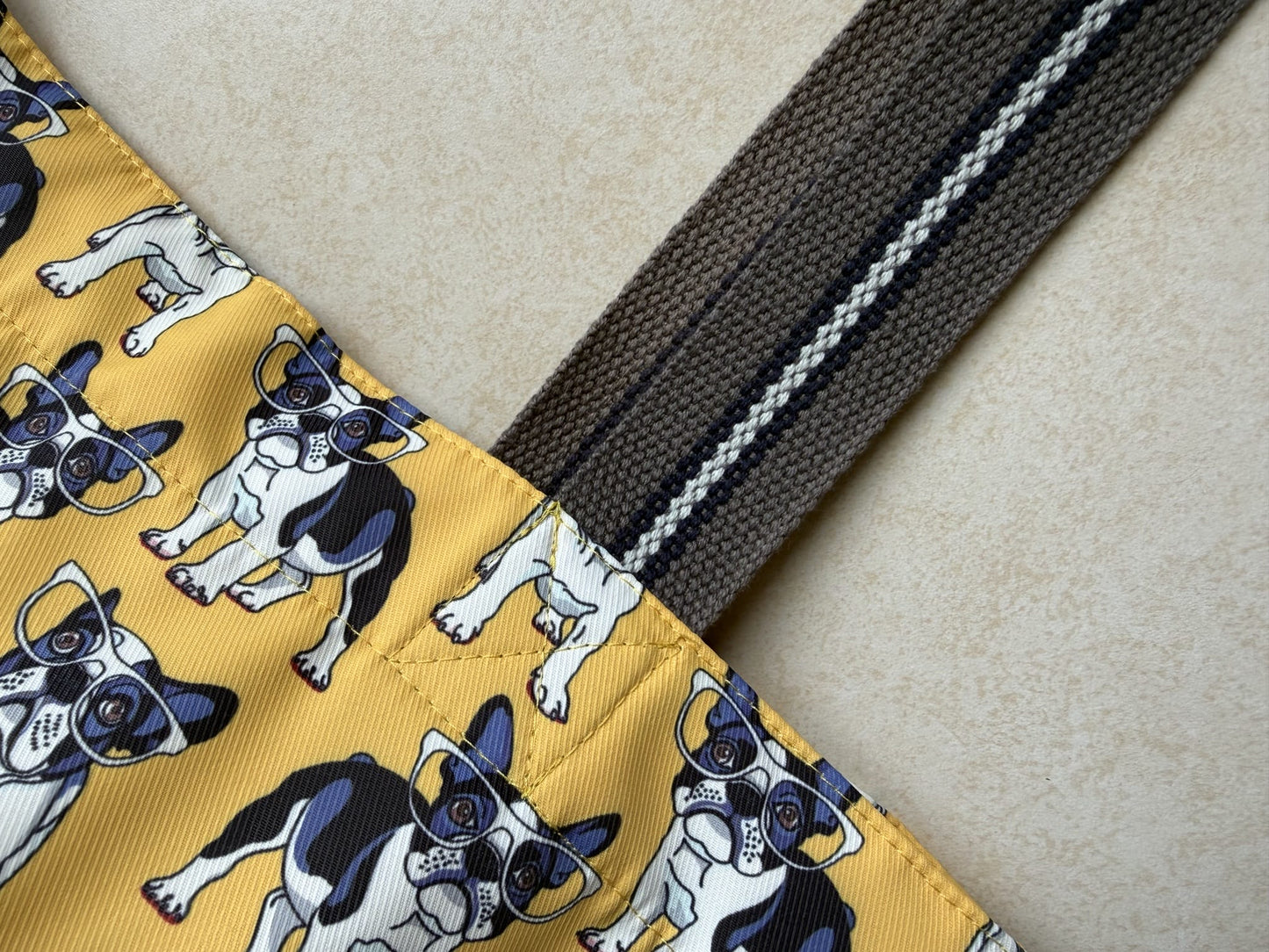 Fabric with dog pattern attached to dark brown straps