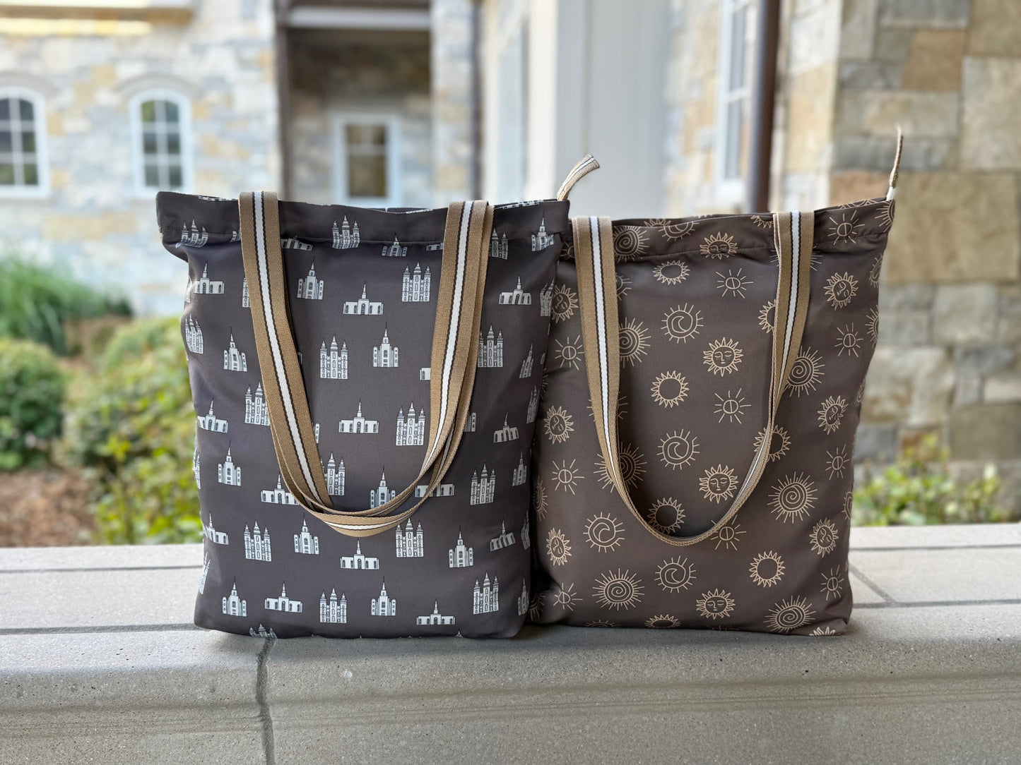 Two LDS temple tote bags side by side, one with white temple designs and the other with sunstone symbols