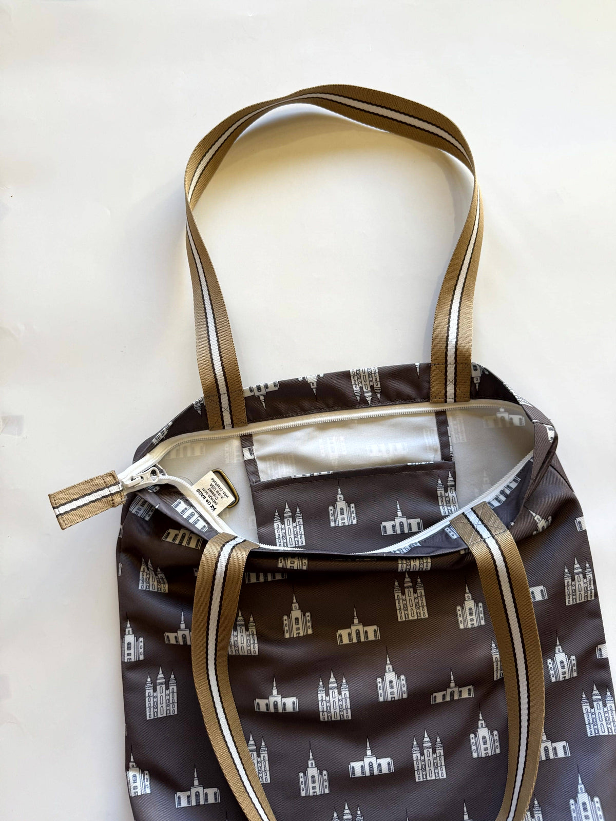 Interior view of temple tote bag showing interior pocket, zipper closure, and built-in keyring