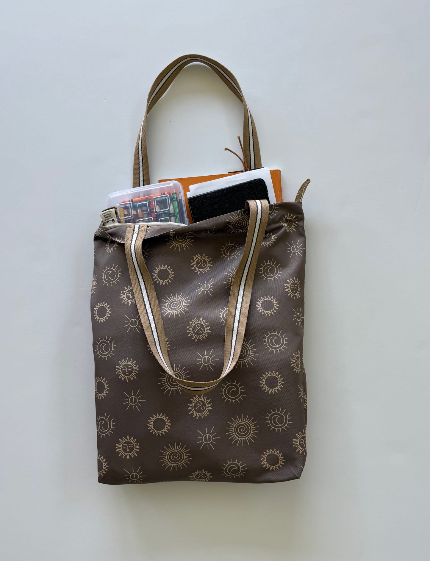 LDS tote bag with sunstone symbols. Partially filled with scriptures, notebook, and crayons