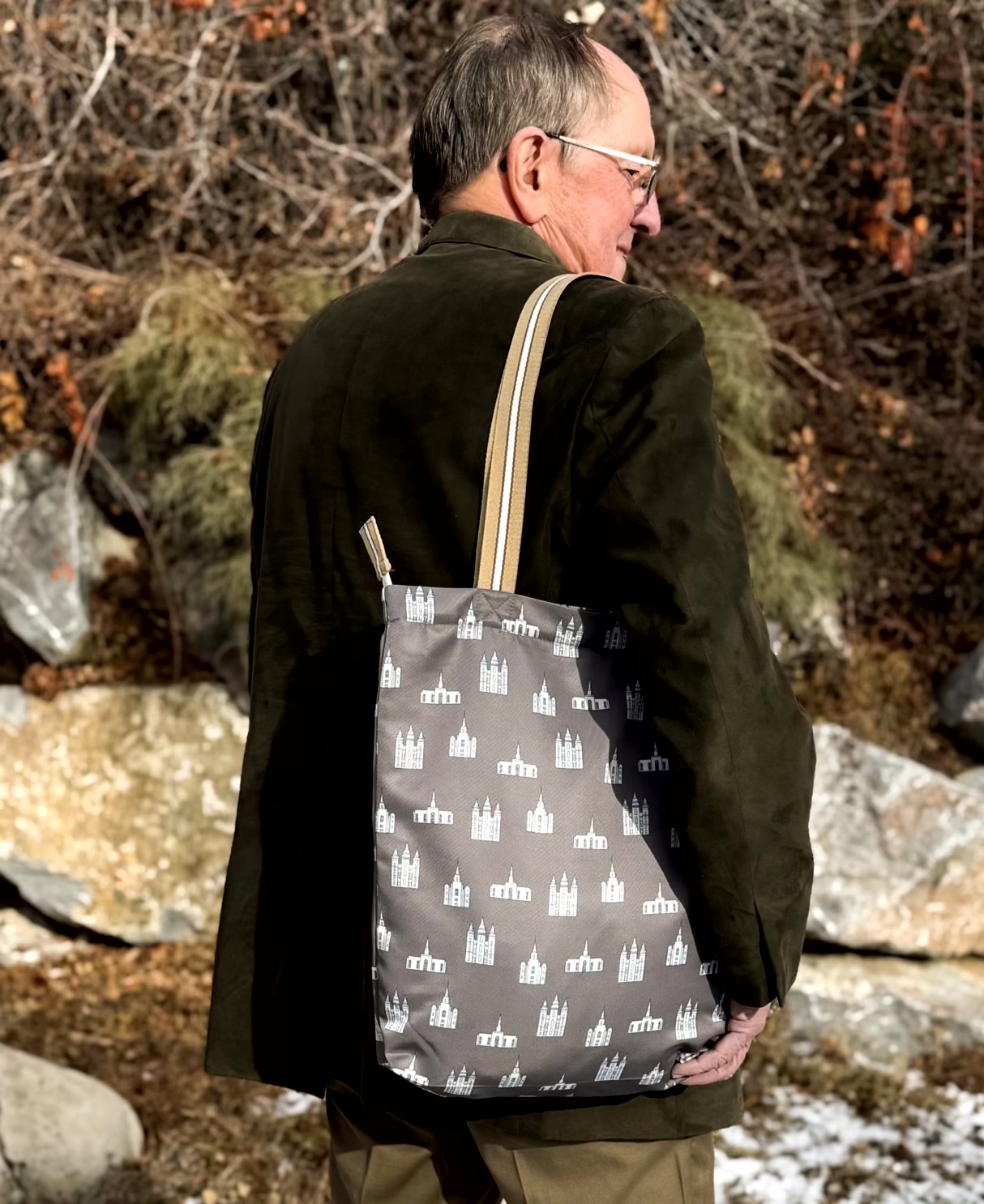 Older man outdoors carrying the temples print LDS tote bag on his shoulder