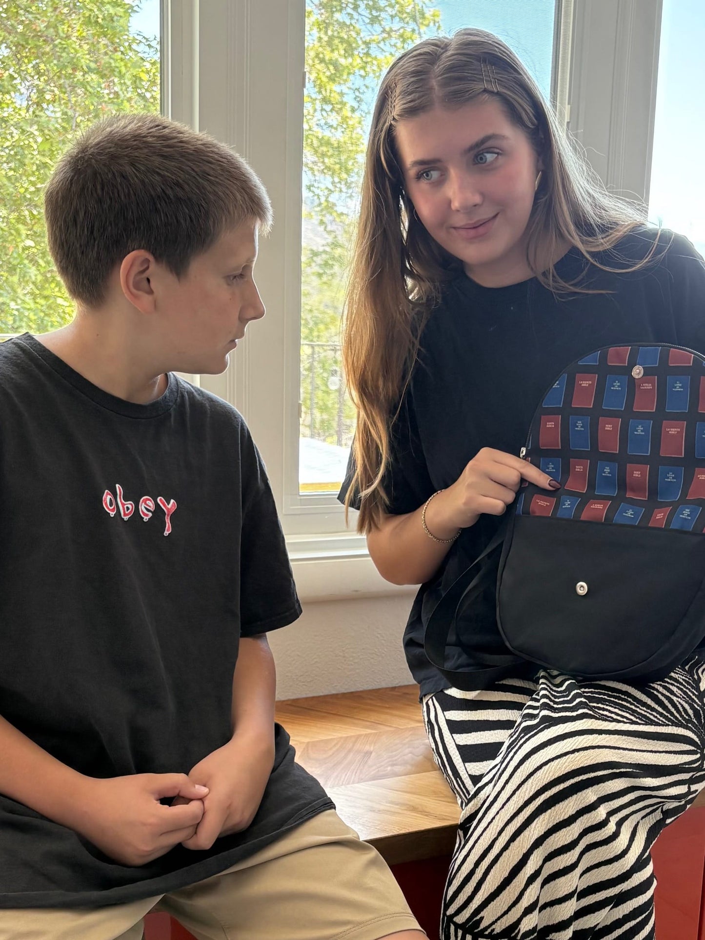 Girl sitting and showing boy the Smiley Bag