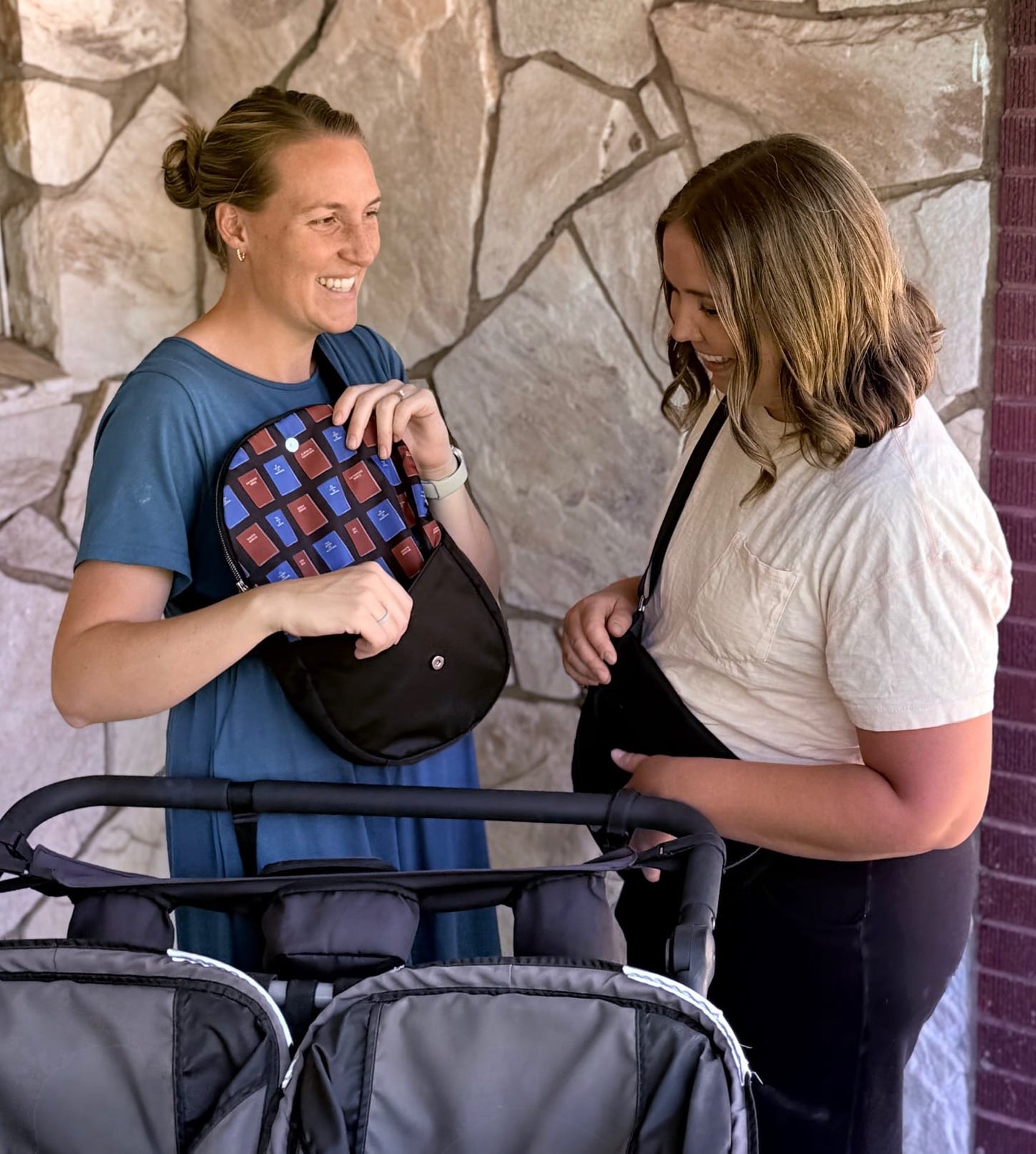 Two mothers standing and carrying Smiley Bags