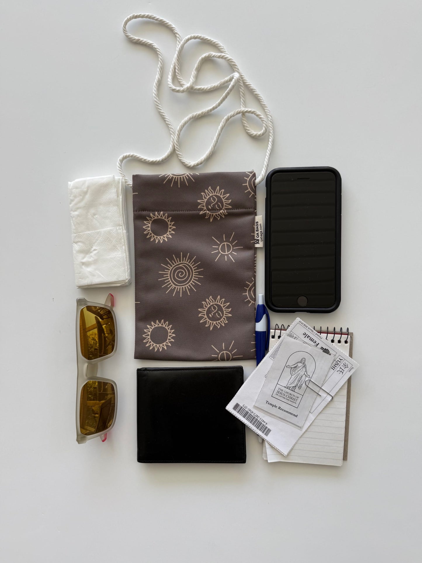 Collection of items including a phone, sunglasses, wallet, stationary, and a pouch to store them