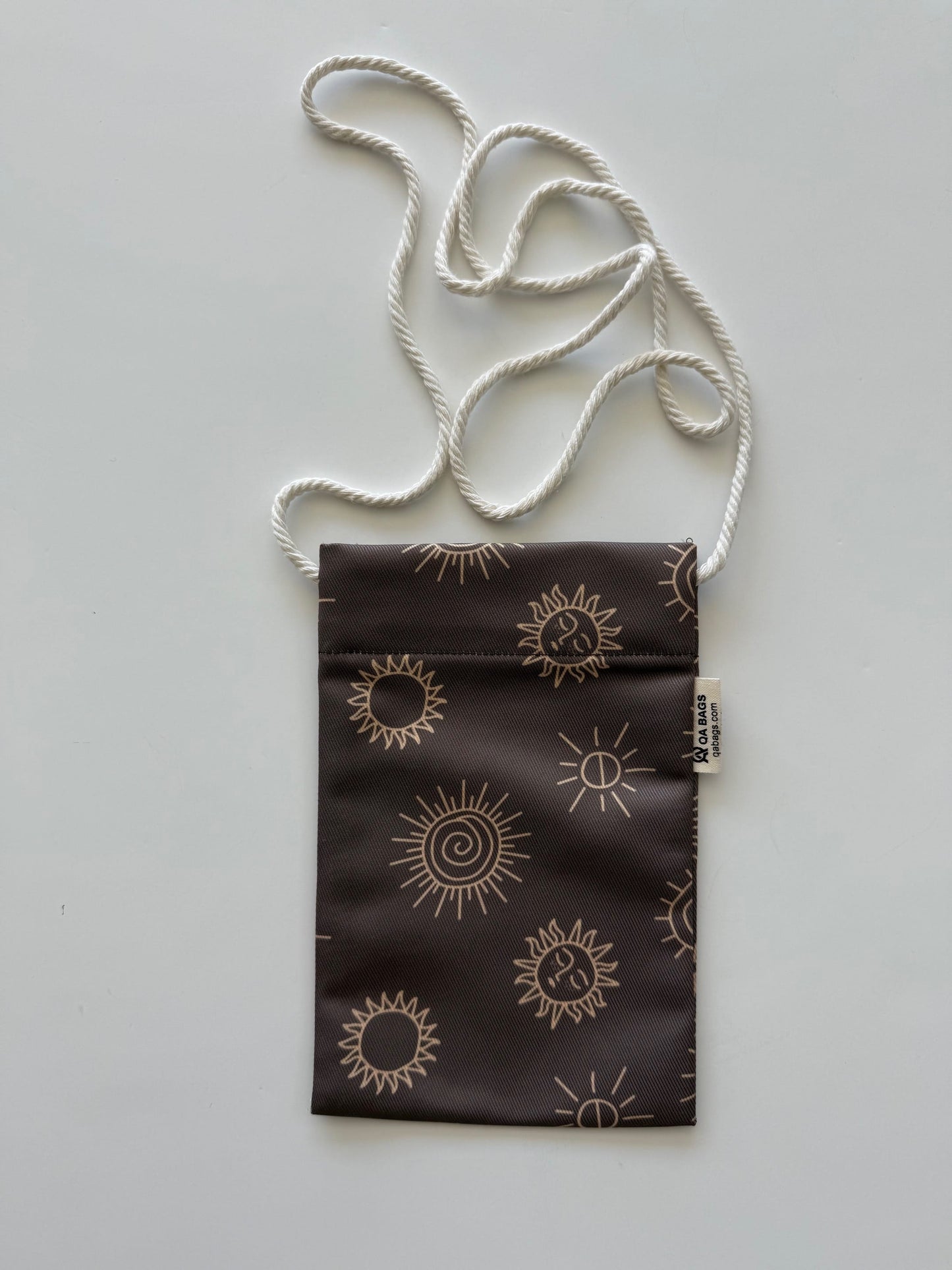 Small brown pouch with sun patterns and a white cotton lanyard