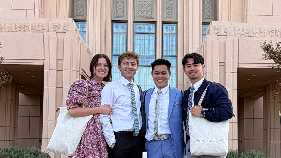 Four individuals posing in front of a The Church of Jesus Christ of Latter-day Saints temple. Two of the individuals are carrying ivory colored temple bags.