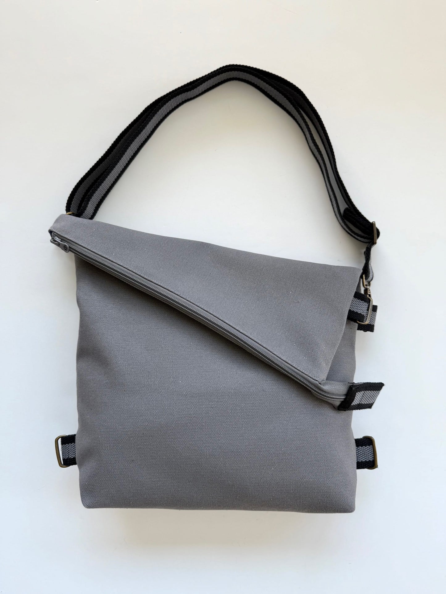 Canvas Gray 3-In-1 convertible missionary bag crossbody style with an adjustable black-and-gray strap.