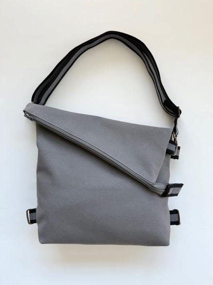 Canvas Gray 3-In-1 convertible missionary bag crossbody style with an adjustable black-and-gray strap.