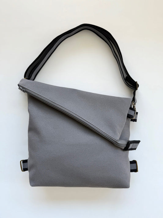 Canvas Gray 3-In-1 convertible missionary bag crossbody style with an adjustable black-and-gray strap.