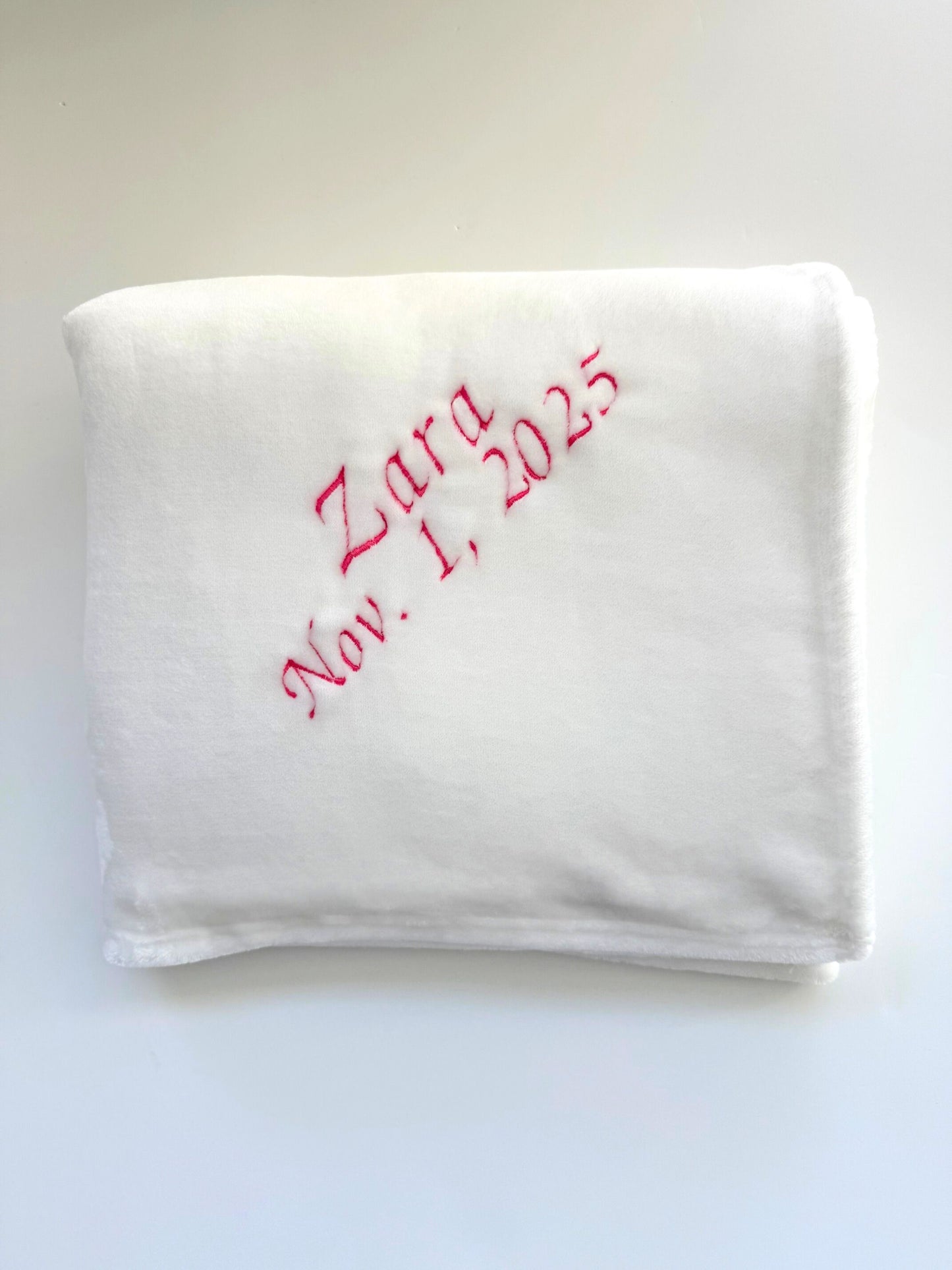White faux fur blanket with pink embroidered text 'Zara Nov. 1, 2025'