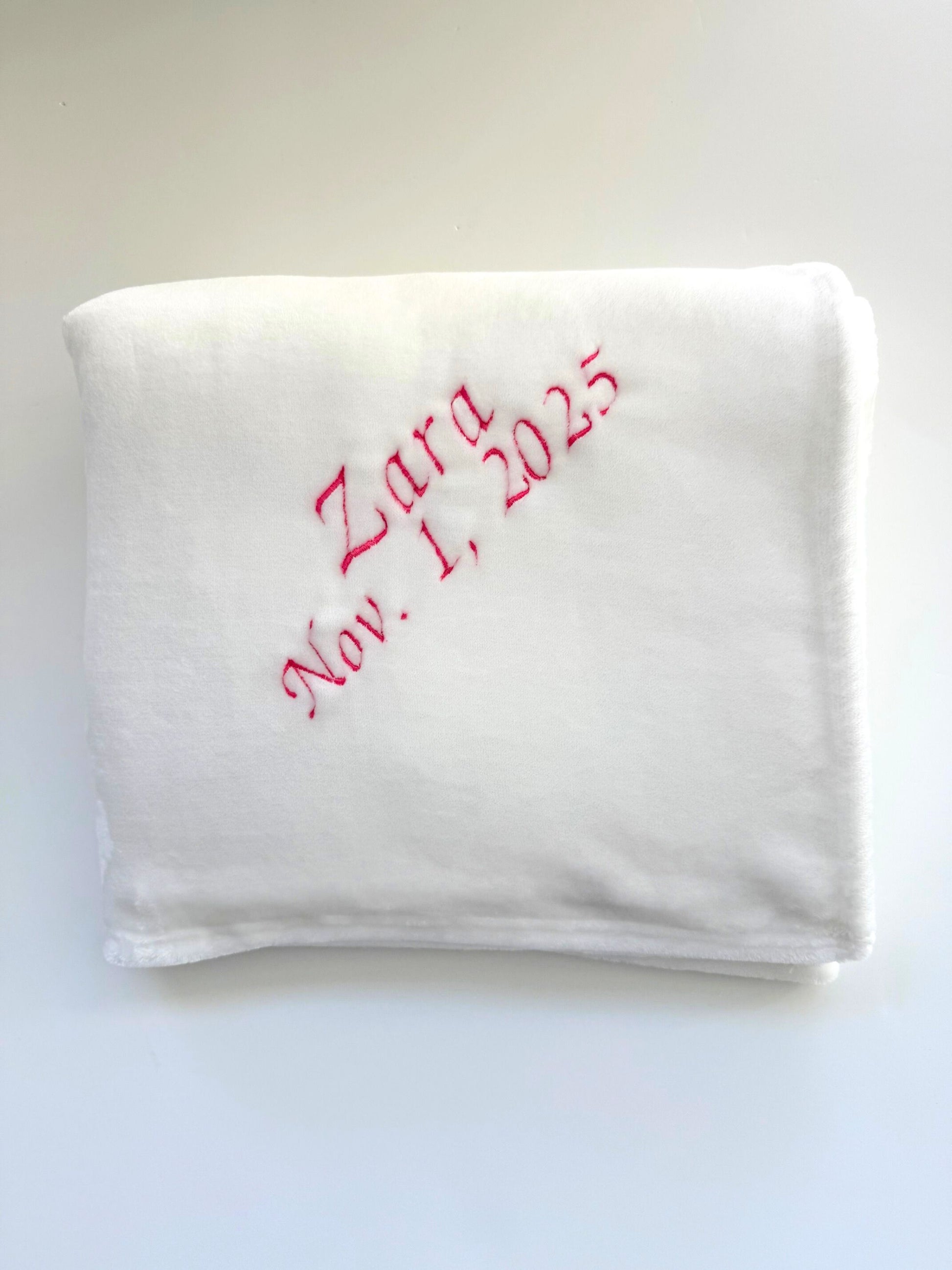 White faux fur blanket with pink embroidered text 'Zara Nov. 1, 2025'