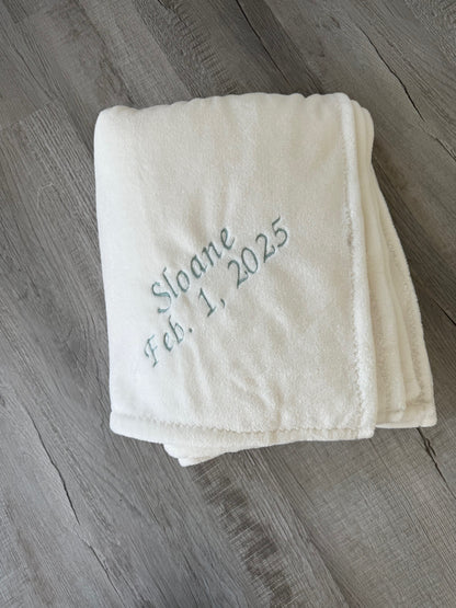 White faux fur blanket with teal embroidered text 'Sloane Feb. 1, 2025'