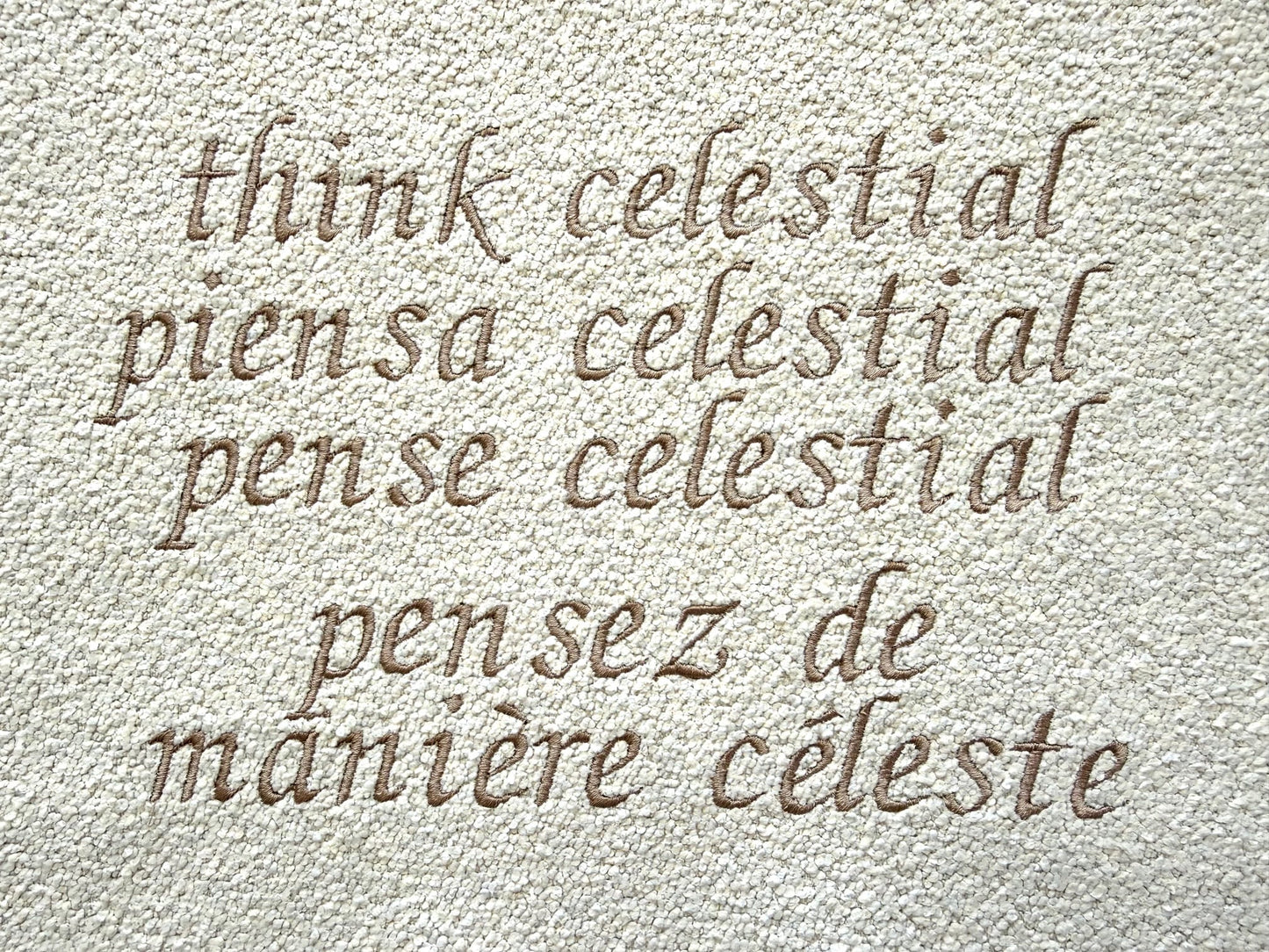 'Think Celestial' in various languages on a textured beige background
