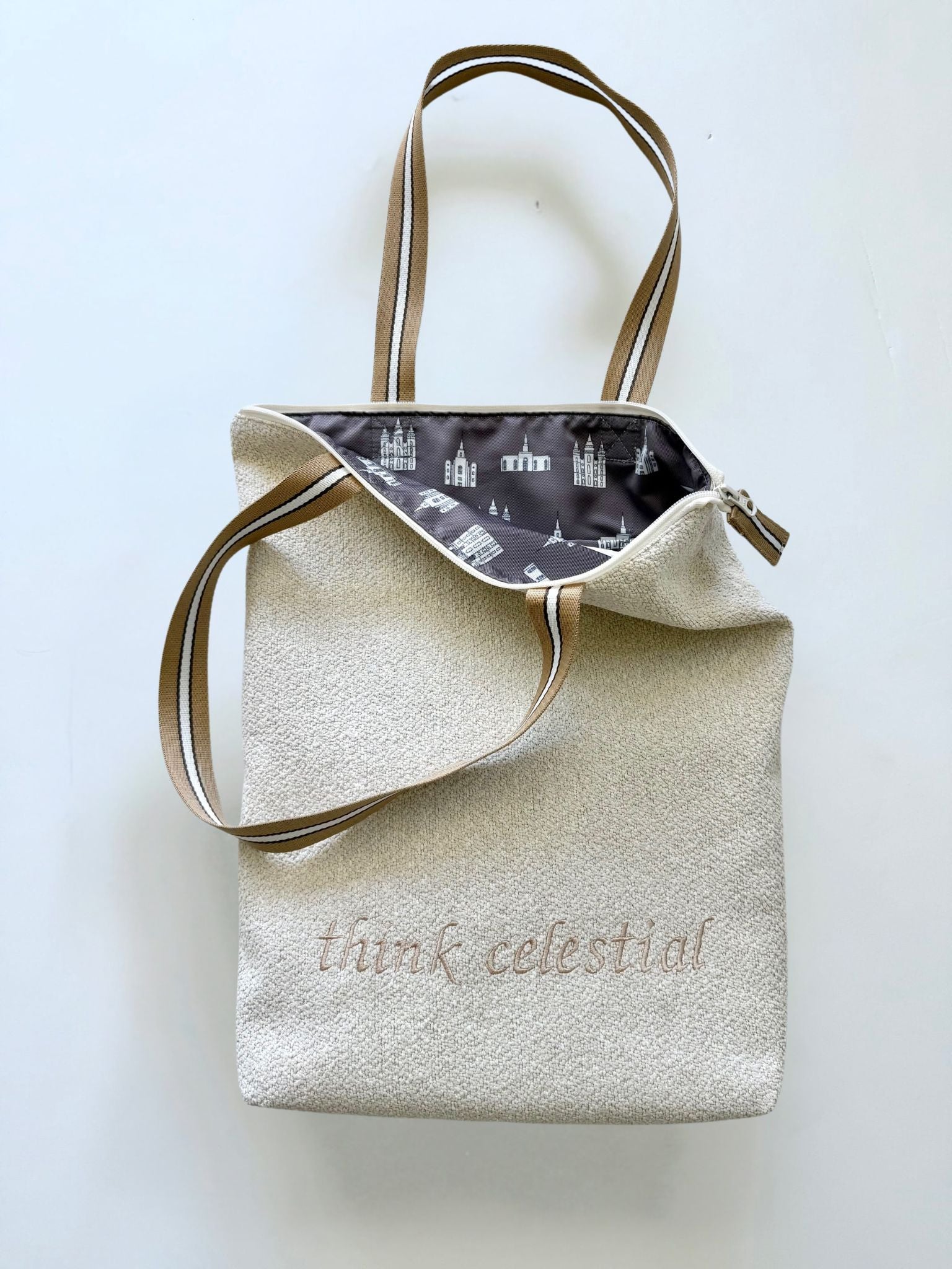 Upholstery Ivory temple bag with white and tan striped strap and temples lining, embroidered with “think celestial”