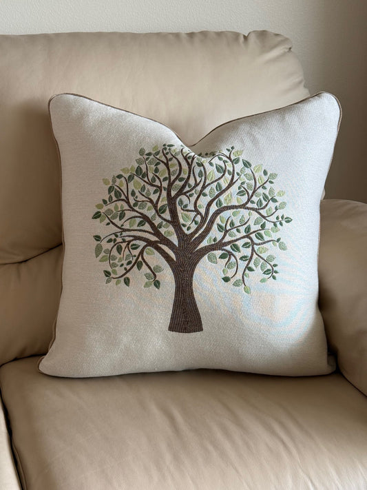 Decorative pillow with a tree design on a beige sofa