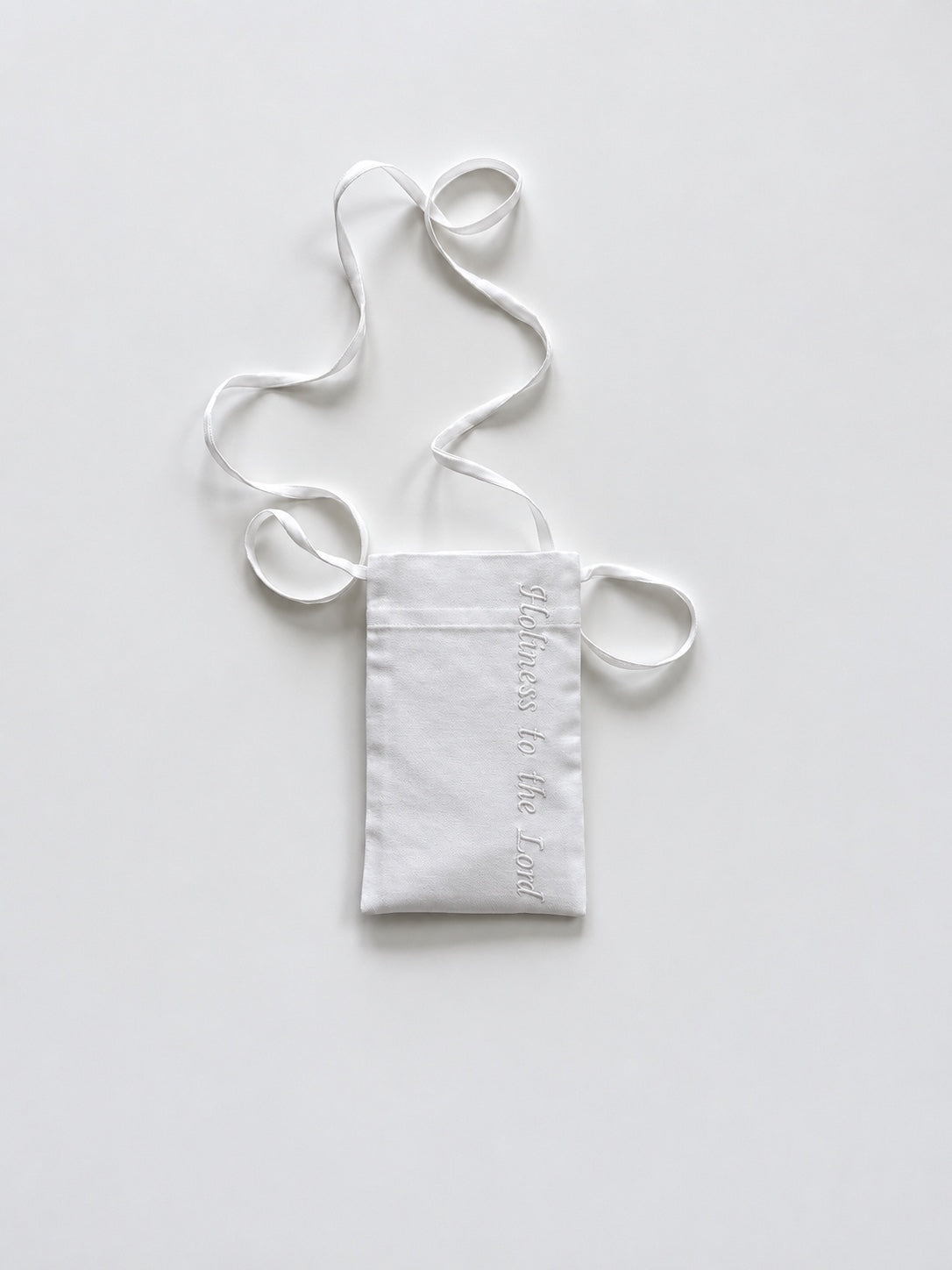 White cotton pouch with a lanyard and the phrase 'Holiness to the Lord' embroidered in white