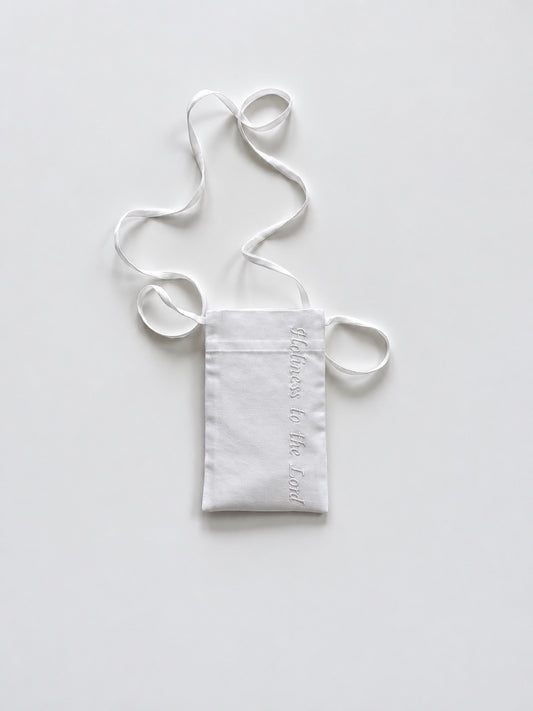 White cotton pouch with a lanyard and the phrase 'Holiness to the Lord' embroidered in white