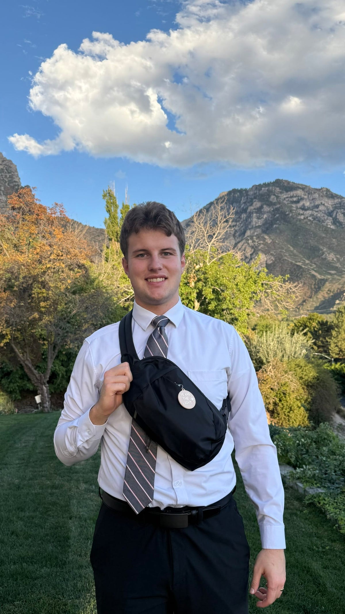 Black LDS Mission Ready Convertible Bag worn in front and across the chest by a man dressed in church attire