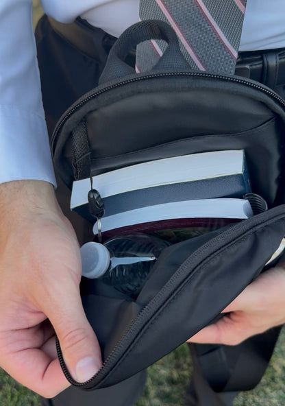Main inside compartment of the Mission Ready Convertible Bag with books, a water bottle, and a key clip inside