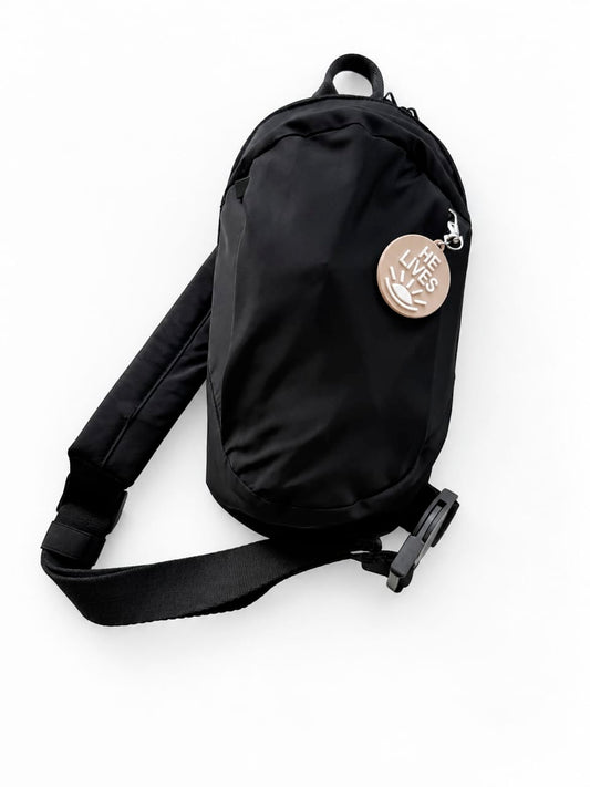 Black LDS Mission Ready Convertible Bag with an adjustable shoulder strap, buckle, and “He Lives” charm
