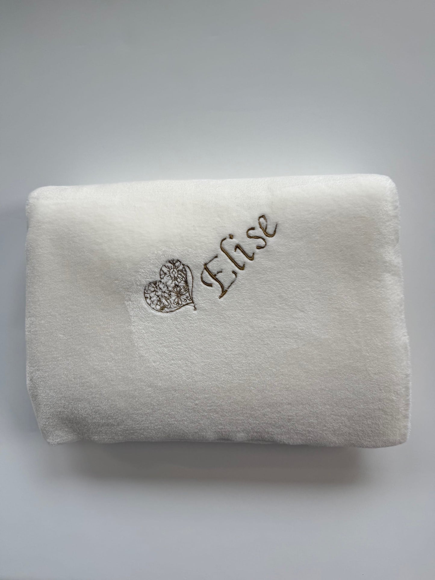 White faux fur blanket with the name 'Elise' embroidered