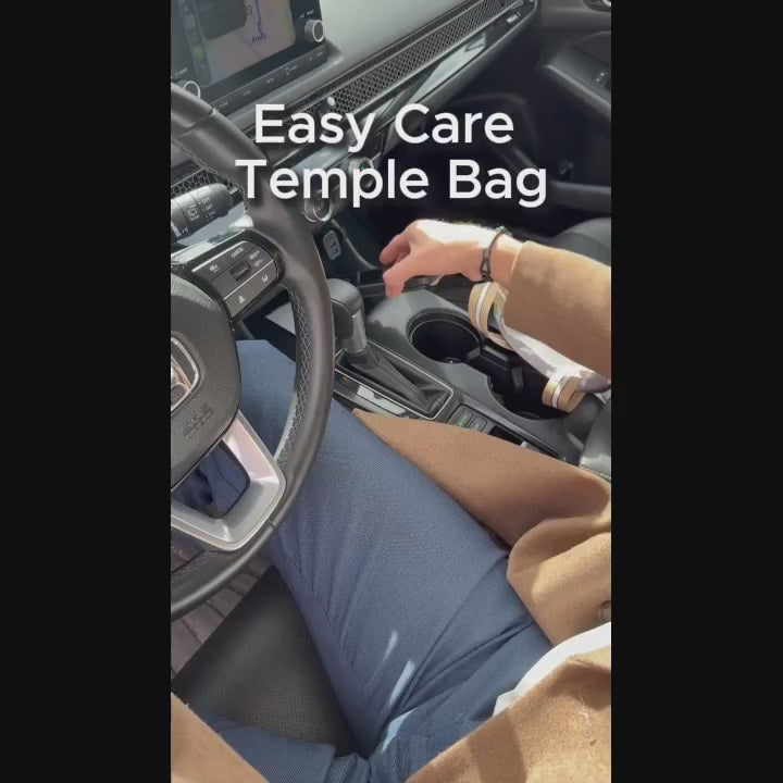 A man places items into his temple bag and walks from his car to the temple grounds while carrying the bag over his shoulder.